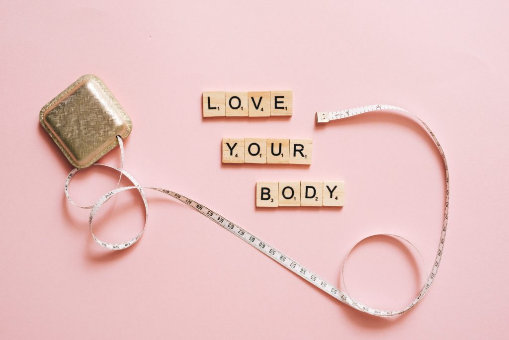 love your body spelled out in scrabble letters with measuring tape
